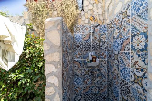a blue and white tiled wall with a bucket on it at Villa Tea con piscina a pochi passi dal mare in Fontane Bianche
