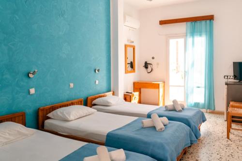 three beds in a room with blue walls at Dilino in Kamari