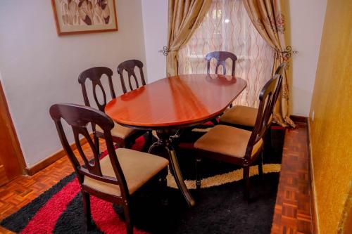 a wooden table and chairs in a room at Riverside Spacious Getaway in Nairobi
