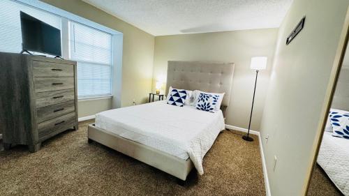 a bedroom with a bed and a dresser with a television at Comfort Escape, rooms in Charlotte with shared common spaces in Charlotte