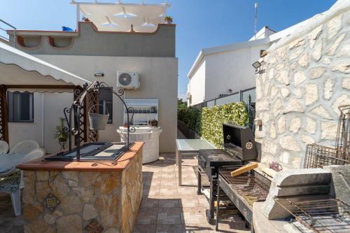a patio with a table and a stone wall at Villa Tea con piscina a pochi passi dal mare in Fontane Bianche