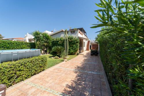 a walkway in a yard with a house at Villa Tea con piscina a pochi passi dal mare in Fontane Bianche