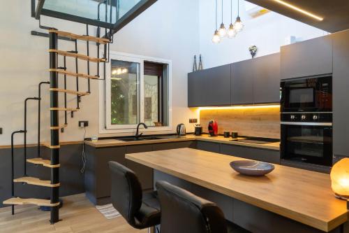 a kitchen with a wooden table and a wooden ladder at Villa Tea con piscina a pochi passi dal mare in Fontane Bianche