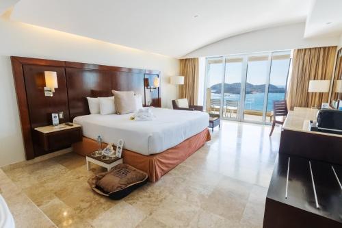 a hotel room with a bed and a television at Azul Ixtapa Grand All Inclusive Suites - Spa & Convention Center in Ixtapa