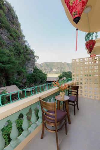 a balcony with chairs and a view of a river at Tam Coc Lion Kings Hotel & Resort Ninh Binh in Ninh Binh