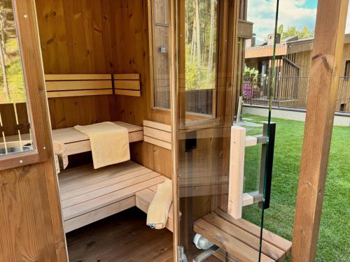 a wooden sauna with two windows in a yard at Monte Sole Suite - mit Sauna & Garten in Perca