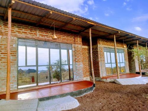 ムトワンブにあるAnapa Lodge and Campのパティオと大きな窓のあるレンガ造りの家