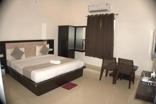 una camera da letto con un letto, un tavolo e delle sedie di The Ashok Heritage Resort & Retreat a Pushkar