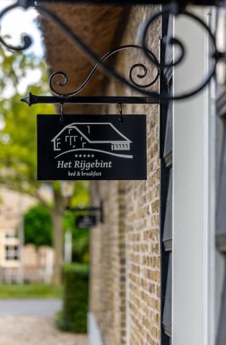 a sign on the side of a building at Luxe B&B Het Rijgebint in Molenaarsgraaf
