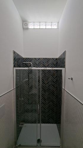 a shower with a glass door in a bathroom at Casetta Giardinetto in Altavilla Milicia