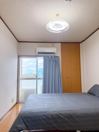 a bedroom with a bed and a large window at 折尾Inホテル305 in Kitakyushu