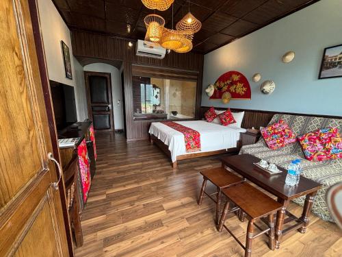 a hotel room with a bed and a couch at Tam Coc Lion Kings Hotel & Resort Ninh Binh in Ninh Binh