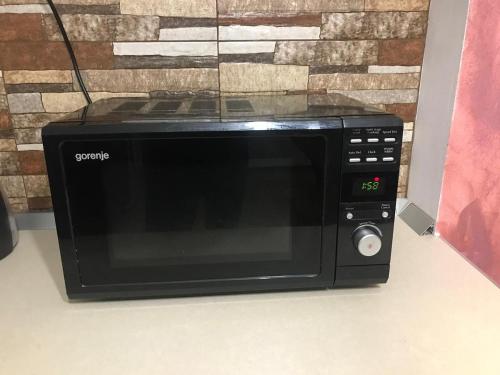 un forno a microonde nero seduto sopra un bancone di The Secret Studios 3 a Craiova