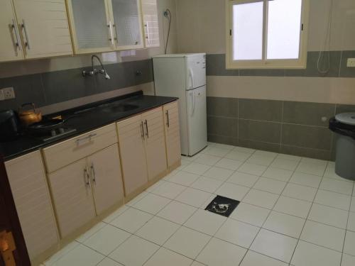 a kitchen with a sink and a refrigerator at ميرال للشقق المخدومة in Abha