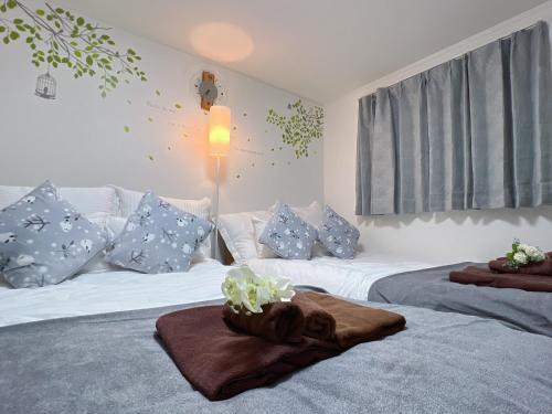 two beds in a bedroom with blue and white pillows at Spacious Cozy house in Shinjuku Free parking wifi in Tokyo