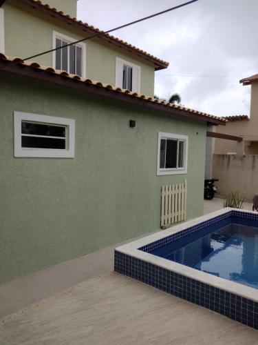 une villa avec piscine devant une maison dans l'établissement Casa em Buzios, à Búzios