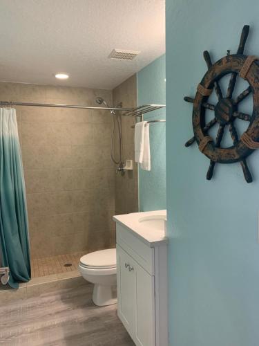 a bathroom with a toilet and a wooden wheel on the wall at Winter Sale on Now-Sunset Vistas 303N 100s 5 stars in St Pete Beach
