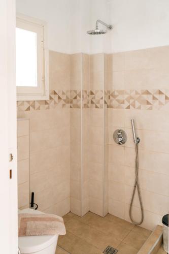 a bathroom with a shower with a toilet and a sink at Dilino in Kamari