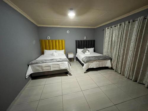 een slaapkamer met twee bedden en een raam bij The Comfort Cottage in Saulspoort