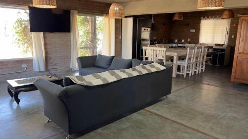 a living room with a couch and a table and a kitchen at La Casona Dique Chico in Villa Anizacate
