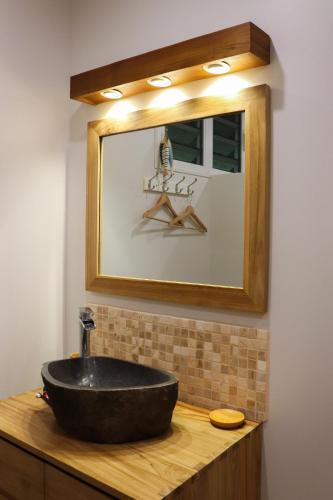 a bathroom with a black sink and a mirror at Blue Bungalow Moorea in Papetoai