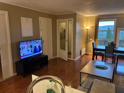 a living room with a television and a table at JECI Apartment Sandvika Bærum - Great view and Attractive in Østre Jong