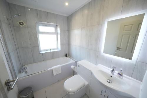a white bathroom with a sink and a toilet at Hatton apartments HEATHROW AIRPORT- FREE parking-Free underground to and from Heathrow Airport Hatton Cross SEE picture-SEE LONDON fast Hatton cross to central London 30min in London