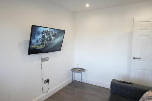 a flat screen tv hanging on a white wall at Hatton apartments HEATHROW AIRPORT- FREE parking-Free underground to and from Heathrow Airport Hatton Cross SEE picture-SEE LONDON fast Hatton cross to central London 30min in London