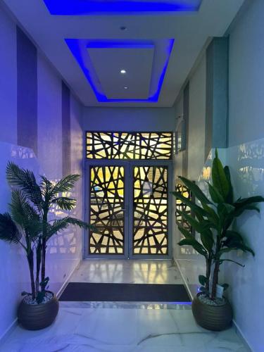 two palm trees in a room with a blue ceiling at l'habitation avec la famille in Fès