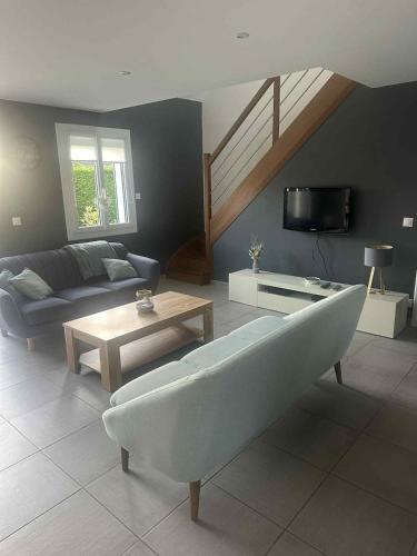 a living room with a couch and a tv at Maison 3 chambres a 5 min de la mer in Etalondes-la-Pipe