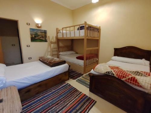 a bedroom with two beds and a bunk bed at Slow Tunis in Fayoum Center