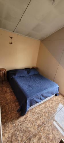 a bedroom with a blue bed in a room at Habitación del Refugio in Puerto Natales