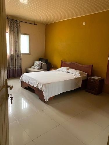 a bedroom with a bed and a chair and a window at Samuge Village in Namacurra