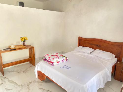 a bedroom with a bed and a table with a pillow at Samuge Village in Namacurra