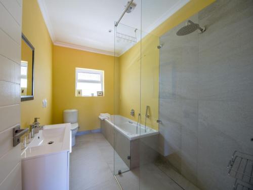a bathroom with a tub and a sink and a shower at Junior-Suite Merlot in Cape Town
