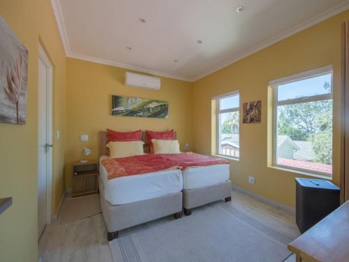 a bedroom with a large bed and two windows at Junior-Suite Merlot in Cape Town