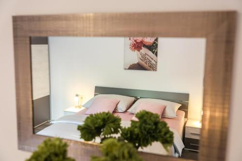 a reflection of a bedroom with a bed in a mirror at Apartment Piano in Rijeka