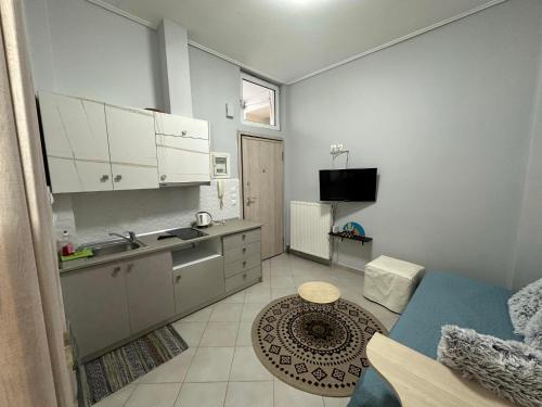 a kitchen with white cabinets and a table in a room at cozy minimal apartment in Piraeus