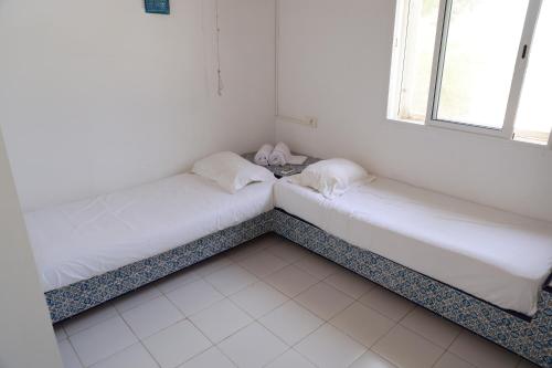 two beds in a room with a window at Les villas Africa Jade in Korba