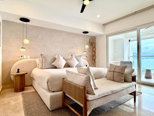 a bedroom with a large bed and a couch at Harbor NT507 by Moikkarentals in Puerto Vallarta
