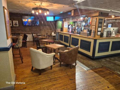 a restaurant with a bar with chairs and tables at The Old Victoria in Penrith