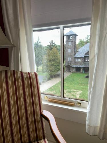 a window with a chair looking out at a house at Silver Bay YMCA Inn and Conference Center in Silver Bay