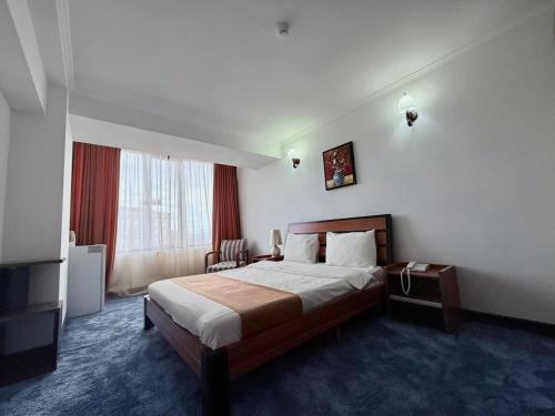 a hotel room with a bed and a television at New Nairi Hotel Yerevan in Yerevan