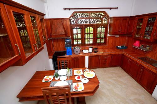 タンガラにあるAetos Wellness & Spa -Tangalleのキッチン(木製のキャビネット、テーブル、食べ物付)