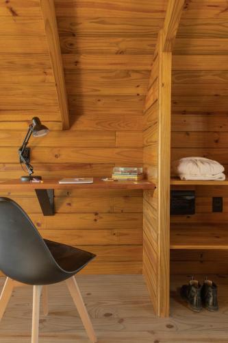 a chair in a room with wooden walls at Chalés do Tabuleiro in Palhoça