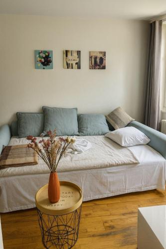 a living room with a couch and a vase on a table at Central & Tranquil by Cathedral in Fribourg