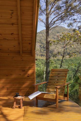 a wooden bench sitting on the porch of a cabin at Chalés do Tabuleiro in Palhoça