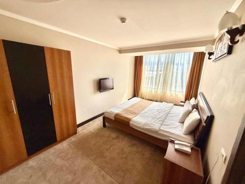 a hotel room with a bed and a window at New Nairi Hotel Yerevan in Yerevan