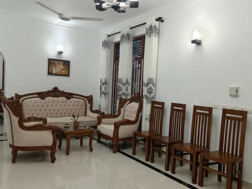 a living room with chairs and a table and a couch at BeeCottageOne-Negombo in Negombo