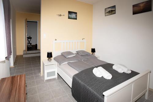 a bedroom with a large bed with two pillows at Harmónia apartman in Zánka